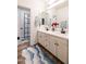 A bright bathroom with double vanity sinks, framed mirrors, and black hardware with a view of the walk-in shower at 20639 W Grandview Dr, Buckeye, AZ 85396