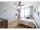 A cozy bedroom with light gray walls, a ceiling fan, and ample natural light provides a relaxing retreat at 20639 W Grandview Dr, Buckeye, AZ 85396