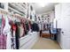 A well-organized walk-in closet features custom storage solutions and a cozy bench, offering style and functionality at 20639 W Grandview Dr, Buckeye, AZ 85396