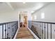 A bright hallway with wood floors connects various rooms in the home with decorative iron railings and arched windows at 20639 W Grandview Dr, Buckeye, AZ 85396