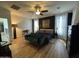 Spacious main bedroom featuring a dark accent wall, hardwood floors, and a cozy green settee at 20639 W Grandview Dr, Buckeye, AZ 85396