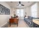 Bright office space with a classic wooden desk, cozy blue sofa, and a decorative ceiling fan at 20639 W Grandview Dr, Buckeye, AZ 85396