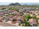 Expansive aerial view showcases a vibrant community with Southwestern-style homes, mature landscaping, and mountain views at 2114 E Escuda Rd, Phoenix, AZ 85024