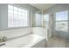 Elegant bathroom featuring a soaking tub, glass block window and separate shower with gold trim at 2114 E Escuda Rd, Phoenix, AZ 85024