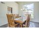 Dining room with large window, a wood table seating six, and a chandelier at 2114 E Escuda Rd, Phoenix, AZ 85024