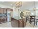 Open kitchen with an island, stainless steel appliances, a dining area, and a view of the living room at 2114 E Escuda Rd, Phoenix, AZ 85024