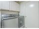 Convenient laundry room with front load washer and dryer and upper cabinets at 2114 E Escuda Rd, Phoenix, AZ 85024