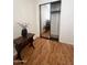 Bedroom boasts a closet with sliding doors, wood-look flooring, and a small accent table at 2115 W Myrtle Ave, Phoenix, AZ 85021