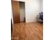 Bedroom featuring wood-look floors, a desk, and a closet with wood sliding doors at 2115 W Myrtle Ave, Phoenix, AZ 85021