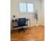 Bedroom featuring wood-look floors, plantation shutters, and a modern desk at 2115 W Myrtle Ave, Phoenix, AZ 85021