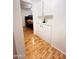 Hallway featuring white cabinets, wood floors, and a glimpse into a bedroom at 2115 W Myrtle Ave, Phoenix, AZ 85021
