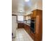 Functional kitchen with wooden cabinets, white appliances, and tiled countertops at 2115 W Myrtle Ave, Phoenix, AZ 85021