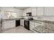 Well-lit kitchen with white cabinets, granite countertops, and sleek black appliances at 2134 W Peninsula Cir, Chandler, AZ 85248