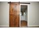 Rustic barn door leading to an ensuite bathroom, adding character to the bedroom at 2150 W Alameda Rd # 1109, Phoenix, AZ 85085