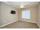 Cozy bedroom with warm paint and carpet, featuring a ceiling fan and wall-mounted tv and a window at 2150 W Alameda Rd # 1109, Phoenix, AZ 85085