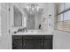 A bathroom with a sleek vanity featuring black cabinets, gold hardware, and a large mirror at 22317 N 39Th Run, Phoenix, AZ 85050