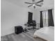 An open bedroom with a dark gray accent wall, sleek ceiling fan, and two large windows at 22317 N 39Th Run, Phoenix, AZ 85050