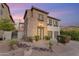 Charming two-story home with stone accents, two-car garage, and desert landscaping in the front yard at 22317 N 39Th Run, Phoenix, AZ 85050