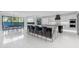 Luxury kitchen with waterfall island, bar seating, and elegant white cabinetry against a backdrop of white tile at 22317 N 39Th Run, Phoenix, AZ 85050