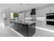 Modern kitchen featuring a large island with marble countertops, white cabinets, and stainless steel appliances at 22317 N 39Th Run, Phoenix, AZ 85050