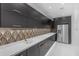 Stylish kitchen featuring dark cabinetry, modern fixtures, and stainless steel appliances at 22317 N 39Th Run, Phoenix, AZ 85050