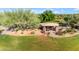 Charming outdoor pavilion with stone pillars, shaded seating, and manicured landscaping at 22317 N 39Th Run, Phoenix, AZ 85050