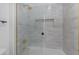 A tiled shower featuring glass doors and gold accents, creating an elegant, modern space at 22317 N 39Th Run, Phoenix, AZ 85050
