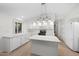 The kitchen area is enhanced with white cabinets and a functional center island and modern appliances at 2434 S Colleen Sw --, Mesa, AZ 85210