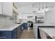 Updated kitchen with marble countertops, white cabinets, blue island, and stainless appliances at 254 W Amoroso Dr, Gilbert, AZ 85233