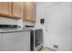 Bright laundry room featuring modern washer, dryer, overhead cabinets, and a convenient built-in lint receptacle at 254 W Amoroso Dr, Gilbert, AZ 85233