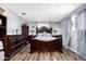 Bedroom showcasing a large decorative dark wood bedframe with side tables and dresser, complementing the wood-look floors at 2650 W Union Hills Dr # 164, Phoenix, AZ 85027