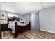 Bedroom features a striking wood-look floor and a stately dark wood bedframe with matching furniture at 2650 W Union Hills Dr # 164, Phoenix, AZ 85027