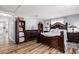 Bedroom features a prominent dark wood bed frame, wood-look floors, and ample storage with matching dresser and shelves at 2650 W Union Hills Dr # 164, Phoenix, AZ 85027
