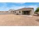 Spacious backyard featuring a covered patio, gravel landscaping, and privacy wall, perfect for outdoor living at 30390 W Mitchell Ave, Buckeye, AZ 85396