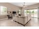 Cozy living room featuring neutral tones, a plush sectional sofa, and sliding glass doors at 30390 W Mitchell Ave, Buckeye, AZ 85396