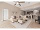 Bright living room featuring neutral tones, a plush sectional sofa, and a ceiling fan at 30390 W Mitchell Ave, Buckeye, AZ 85396