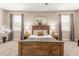 Comfortable main bedroom featuring a king bed, neutral tones, and two windows at 30390 W Mitchell Ave, Buckeye, AZ 85396