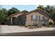Beautiful single-story home featuring stone accents, neutral-colored exterior, desert landscaping, and an attached two-car garage at 316 S San Christo Ln, Casa Grande, AZ 85194