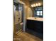 Bathroom featuring a shower-tub combo, well-lit mirror and dark cabinetry at 324 N 56Th Pl, Mesa, AZ 85205