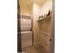 This laundry room features a stacked washer and dryer and shelving unit, adding functionality to the home at 324 N 56Th Pl, Mesa, AZ 85205