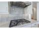 Close-up of a KitchenAid gas range with a sleek vent hood and stylish backsplash on marble countertop at 3332 S Quinn Ave, Gilbert, AZ 85297