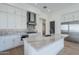Open kitchen features a marble island, modern vent hood, stainless appliances, and white cabinets at 3332 S Quinn Ave, Gilbert, AZ 85297