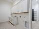 Well-lit laundry room with ample storage, countertops, and modern appliances at 3332 S Quinn Ave, Gilbert, AZ 85297