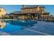 Community pool with lounge chairs, umbrellas, and clubhouse, creating a relaxing environment at 3332 S Quinn Ave, Gilbert, AZ 85297