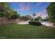 Expansive backyard with lush green lawn, mature trees, and an outdoor pizza oven at 3417 E Mission E Ln, Phoenix, AZ 85028
