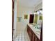 Bright bathroom featuring a double vanity, tile countertop, and decorative accents at 3417 E Mission E Ln, Phoenix, AZ 85028