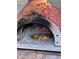 A rustic, outdoor pizza oven with a freshly baked pizza inside, offering a delightful culinary experience at 3417 E Mission E Ln, Phoenix, AZ 85028