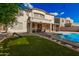 Spacious backyard with lush artificial grass, pool, and covered patio provides an ideal space for relaxation and play at 3680 S Tower Ave, Chandler, AZ 85286