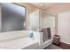 Bright bathroom featuring a soaking tub, shower with glass door, and neutral decor at 3680 S Tower Ave, Chandler, AZ 85286