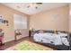 Cozy bedroom with a ceiling fan, window, and comfortable gray upholstered bed for restful nights at 3680 S Tower Ave, Chandler, AZ 85286
